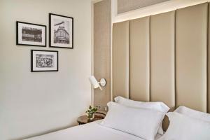 马德里NH马德里纳克纳尔酒店的配有床和2个枕头的酒店客房
