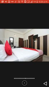 哈里瓦Hotel Shiva Palace haridwar nearby bus and railway station的卧室配有带红色枕头的白色床