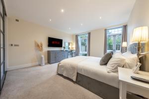 特威克纳姆Candler Mews - Twickenham的卧室配有一张白色大床和一张书桌