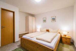 巴特尚道Ferienwohnung zur Steinburg的一间卧室配有一张带白色床单和两盏灯的床。