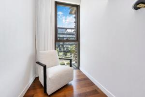 迪拜FAM Living - City Walk - Opulent Living的走廊上的白色椅子,带窗户