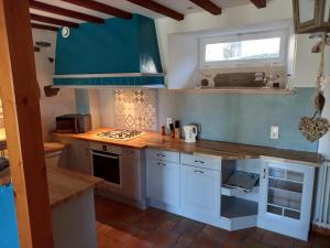 NébouzatGites et Cocon des Puys的厨房配有白色橱柜和蓝色台面