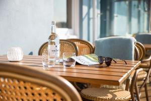 格雷The Moorings Hotel & Restaurant的木桌上放一瓶葡萄酒和玻璃杯
