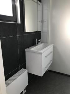 恩克赫伊曾Chalet Sonnenplätzchen Zweite Reihe Haus Nr 229的白色的浴室设有水槽和镜子