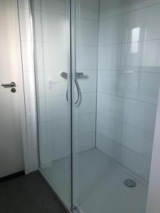 恩克赫伊曾Chalet Sonnenplätzchen Zweite Reihe Haus Nr 229的浴室里设有玻璃门淋浴