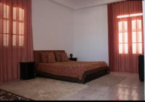 乌姆苏克MB SWEET HOME DJERBA的一间卧室设有一张床和两个窗户。
