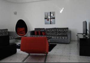 乌姆苏克MB SWEET HOME DJERBA的带沙发和红色椅子的客厅