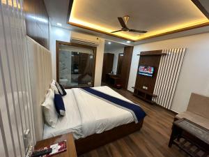 阿格拉Hotel The Rich Grand Agra的一间卧室配有一张带吊扇的床