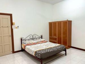 太平Merdeka 19的一间卧室配有一张床和一个木制橱柜