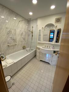 蒂蒂湖-新城VOLLMER home的白色的浴室设有浴缸和水槽。