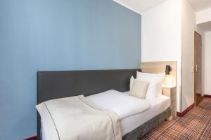 埃森theAmbassador Hotel I Essen City的卧室配有白色床和蓝色墙壁