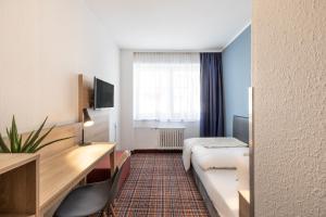 埃森theAmbassador Hotel I Essen City的配有一张床和一张书桌的酒店客房