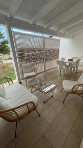 托雷拉皮罗Dimora Arnesano的庭院配有椅子和桌椅