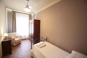 卡斯特利纳-因基安蒂卡萨莱德乐斯帕维罗农家乐的卧室配有床、椅子和窗户。