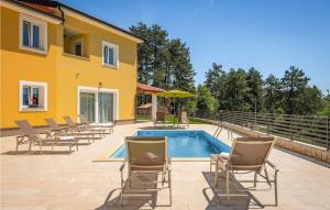 莫什尼卡德拉加Villa Terra的一个带椅子的庭院、一个游泳池和一个房子