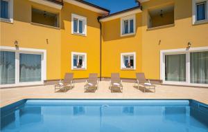 莫什尼卡德拉加Villa Terra的一座黄色的建筑,配有椅子和游泳池