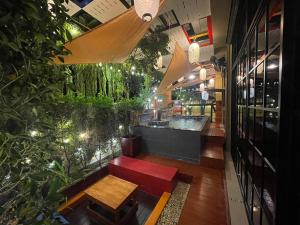 Ban Chak Khaminอีโฮสเทลบ้านช่น的一间带长凳的餐厅和一间种植了植物的酒吧
