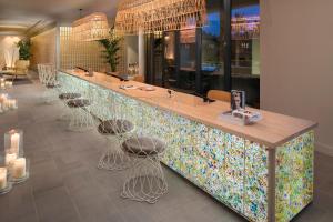 锡切斯特乐玛ME锡切斯酒店的餐厅设有色彩缤纷的柜台和凳子