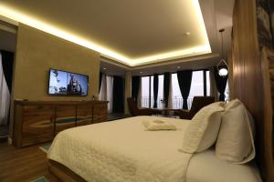 波格拉德茨Hotel 1 Maji的酒店客房,配有床和电视