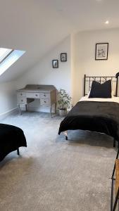 哈罗盖特Modern Harrogate house sleeps 10, cinema room & hot tub的一间卧室配有一张床和一张书桌