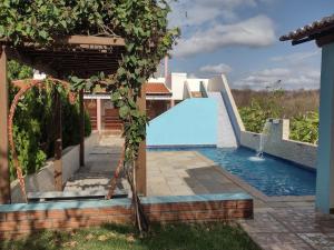 Lavras da MangabeiraCHACÁRA SOL NASCENTE的游泳池,位于带游泳池的房子里