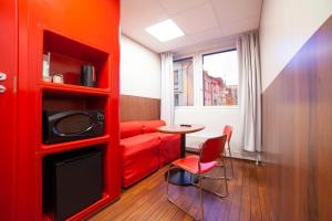 赫尔辛基赫尔辛基市中心奥梅那酒店的红色的客厅配有红色的沙发和桌子