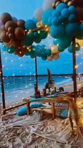 布兰卡滩SUNSET BEACH的海滩上的一张遮阳伞下的野餐桌