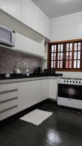 乌巴图巴excelente casa ótima localização的厨房配有白色橱柜和炉灶烤箱。