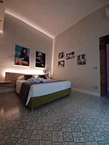 那不勒斯Domus Duomo B&B Napoli的卧室配有一张床,墙上挂有图片