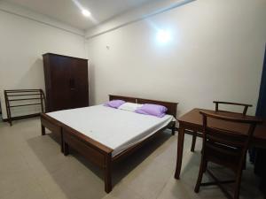 迪加纳Victoria Nature Resort的卧室配有一张床和一张桌子及椅子