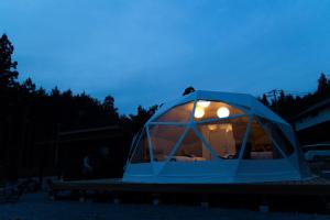 Mizunami里山グランピングむすびペット棟的夜晚带灯光的蓝色伊瓜纳帐篷