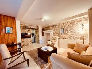 福卡Time Traveler's House - Eski Foça的带沙发和石墙的客厅