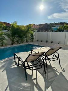 威廉斯塔德Villa Vista Montaña的游泳池旁的桌椅
