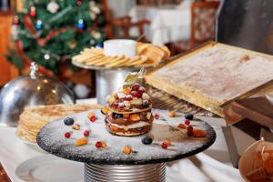 班斯科Pirin Golf Hotel & Spa的圣诞树前的餐桌上的甜点
