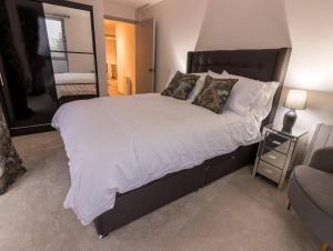 浦耳Coastal Cove的卧室配有一张带白色床单和枕头的大床。