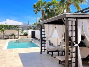 棕榈滩阿鲁巴拉古尼塔公寓的一座带游泳池和凉亭的房子
