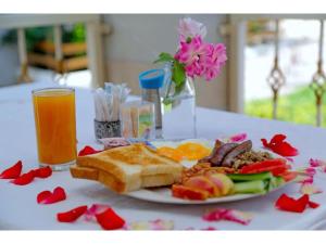 恩德培大猩猩非洲旅馆的一小盘食物,包括面包和水果以及一杯橙汁