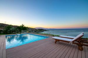 圣尼古拉奥斯Villa Vrahos - Deja Vu Villas的一个带长凳的游泳池,位于一个享有海景的甲板上