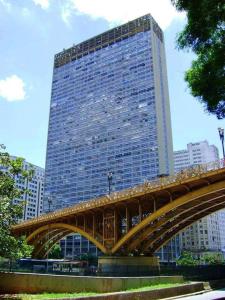 圣保罗Loft 37 Centro histórico的前面有一座高大的建筑,前面有一座桥梁