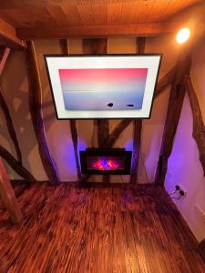 卡德纳姆Cozy Cottage with hot tub!的铺有木地板的客房内配有平面电视