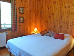 博福特Chalet Arêches-Beaufort, 5 pièces, 6 personnes - FR-1-342-225的一间卧室配有一张带木墙的大床