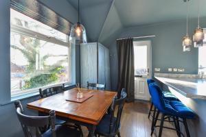 诺丁汉Fairview Boutique Apartments in West Bridgford Centre的一间带木桌和蓝色椅子的用餐室