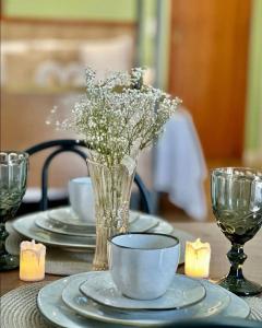 圣若泽Apartamentos - Estúdios的一张桌子,上面有盘子和花瓶