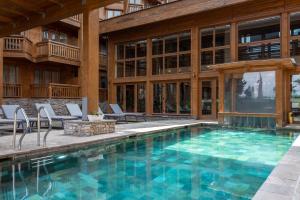 班斯科Luxury Chalets Pirin Golf & Country Club的一座带椅子的室内游泳池和一座建筑