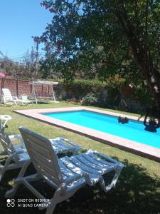 维库尼亚Habitación matrimonial deluxe Casa Tierra Elquina的游泳池旁的两把草坪椅