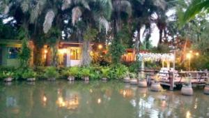邦萨雷สวนผึ้ง2 รีสอร์ท - Suan Phueng 2 Resort的水面上的房子,前面有船