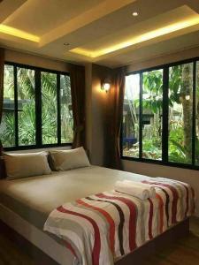 邦萨雷สวนผึ้ง2 รีสอร์ท - Suan Phueng 2 Resort的配有大窗户的客房内的一张大床