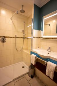 蒙特利马尔Cit'Hotel Sphinx - Hotel的带淋浴、盥洗盆和浴缸的浴室