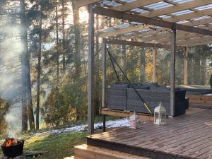 Tammemäe Spa Lodge的木甲板上的凉亭和烧烤架