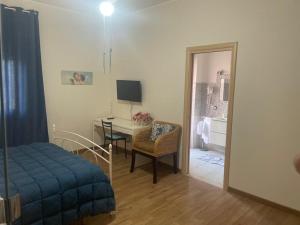 阿普里利亚OLEANDRI SUITE B&B的客房设有带书桌和床的卧室。